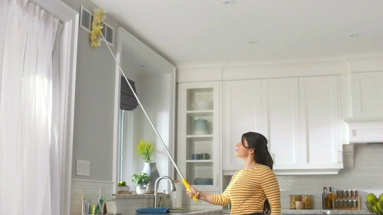 Woman using Swiffer Duster to clean vent in home
