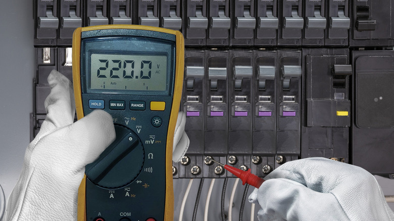 An electrician testing a circuit breaker panel