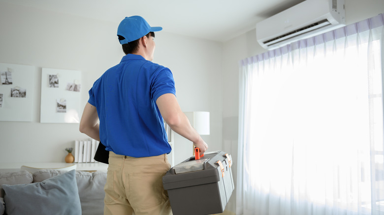 A service tech for AC in a home with a toolkit