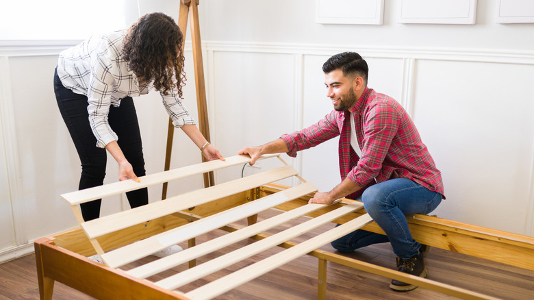 A couple assembling a bedframe