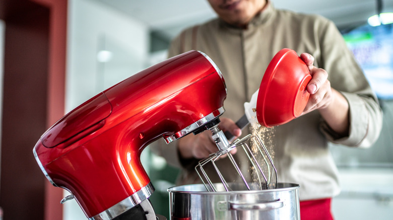 person using stand mixer on counter