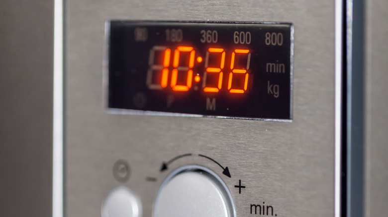 A stainless steel microwave with close-up of clock display