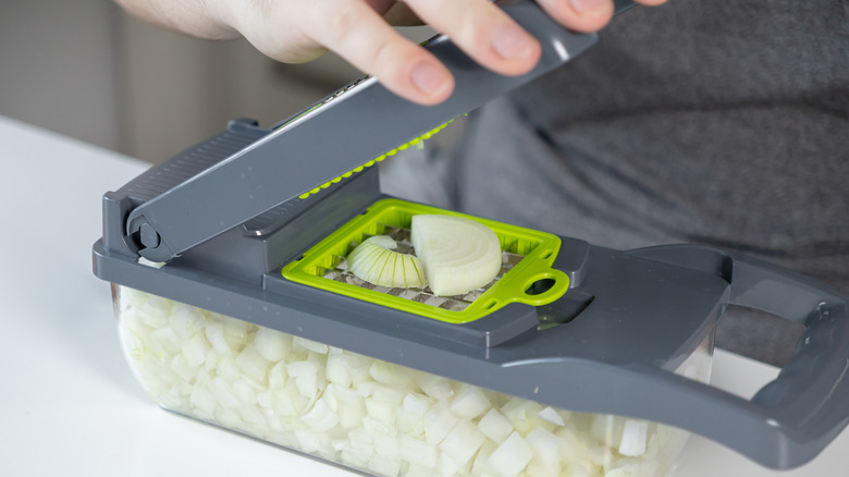 person using vegetable chopper for onion