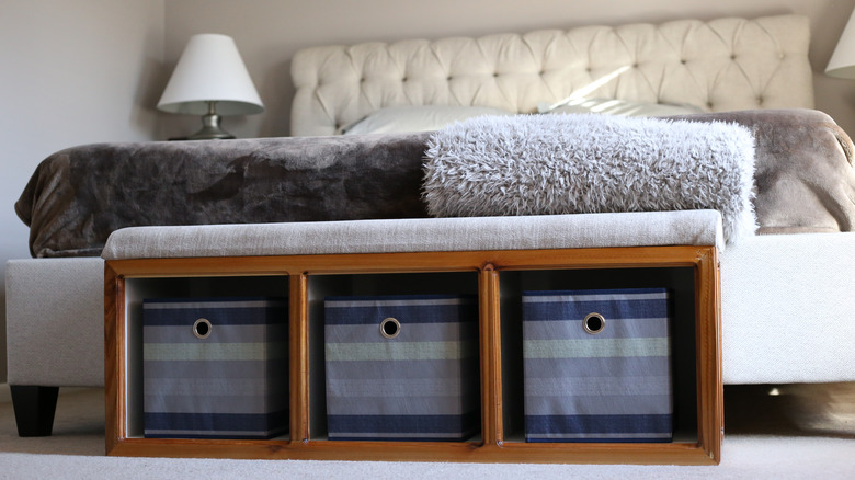 A storage bench with cubbies in a bedroom.