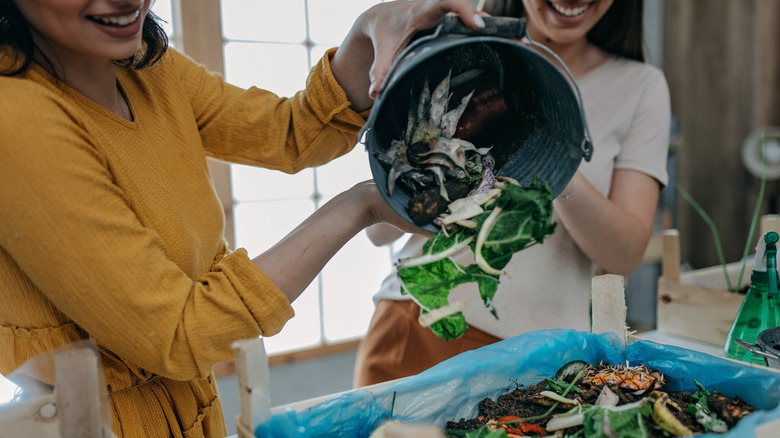 two women dumping food waste
