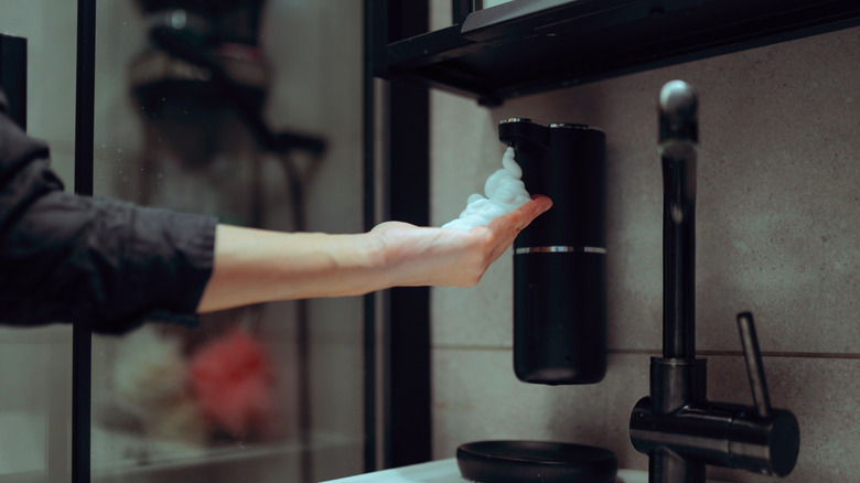 person using automatic soap dispenser