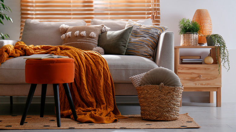 Footstool with red fabric that contrasts with other furniture colors