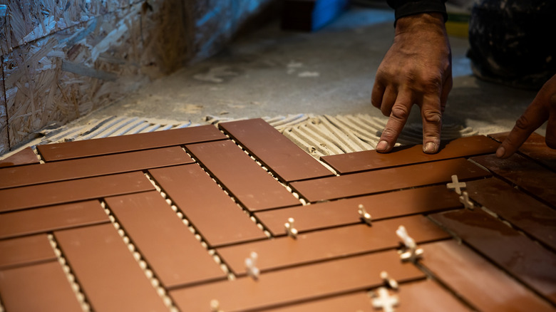 Person installing herringbone tiles