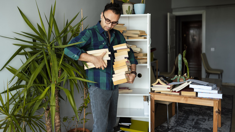 man organizing books