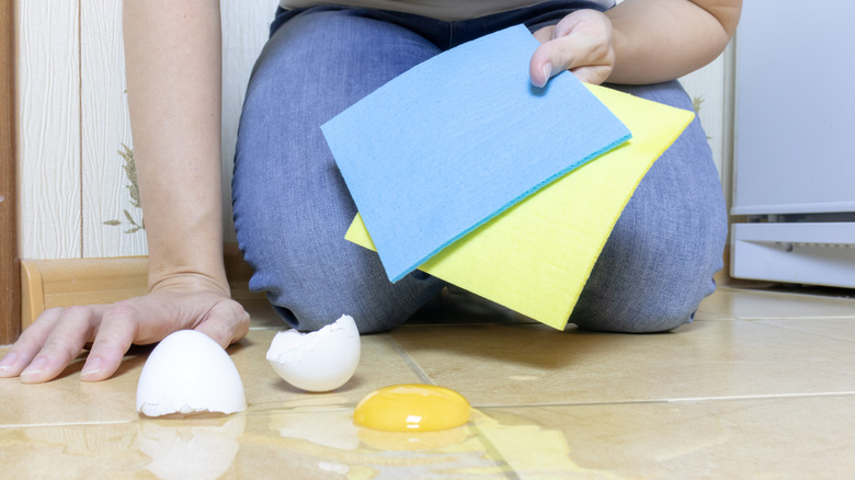 Person preparing to clean egg mess off floor