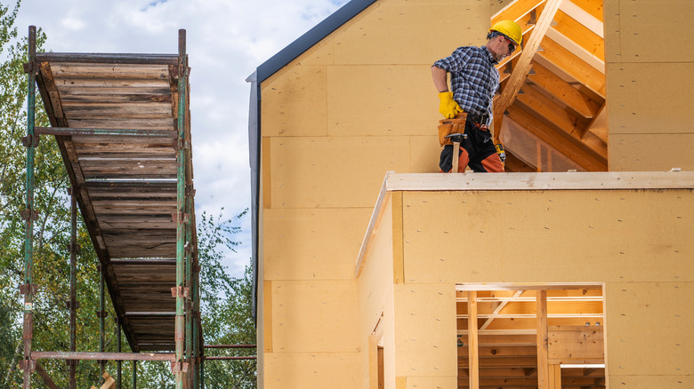 contractor standing on roof of house being built
