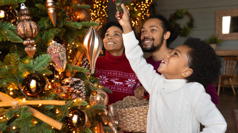 Family decorating Christmas tree