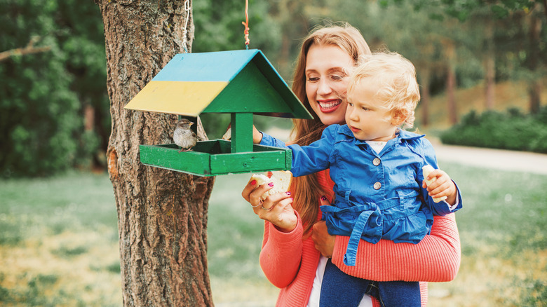 mother and child feeding birds