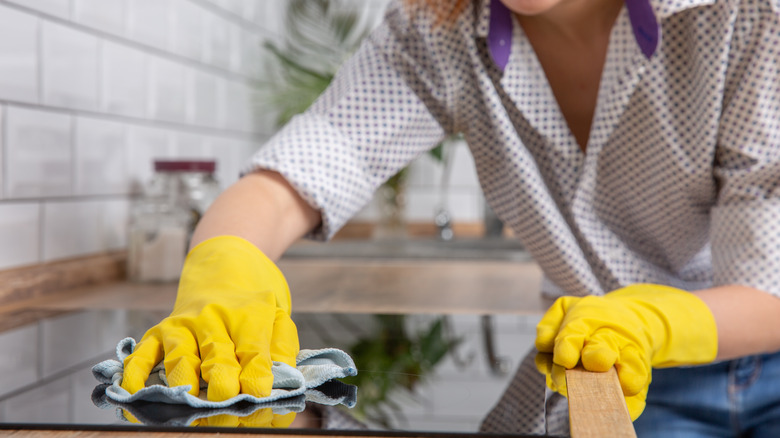 Person cleaning ceramic stovetop