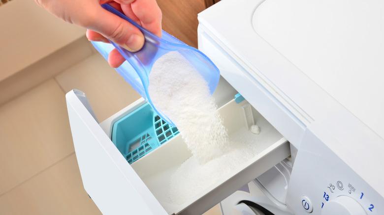 Pouring powder soap into washing machine