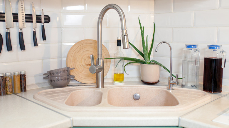 A pale pink corner kitchen sink
