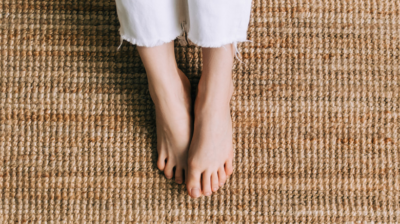 closeup of woman's bare feet on a jute rug