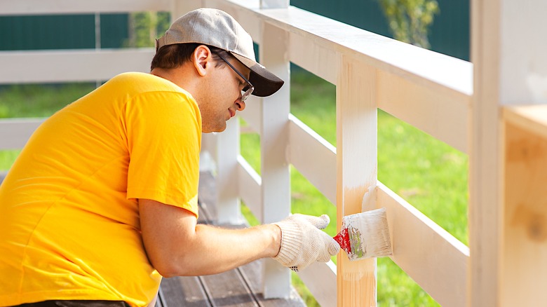 Man painting his porch white