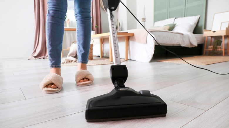 Woman vacuuming laminate bedroom floors