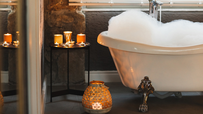 A bathtub surrounded by dimly lit candles