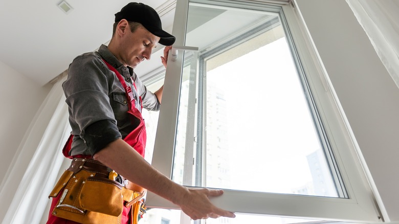 man installing window