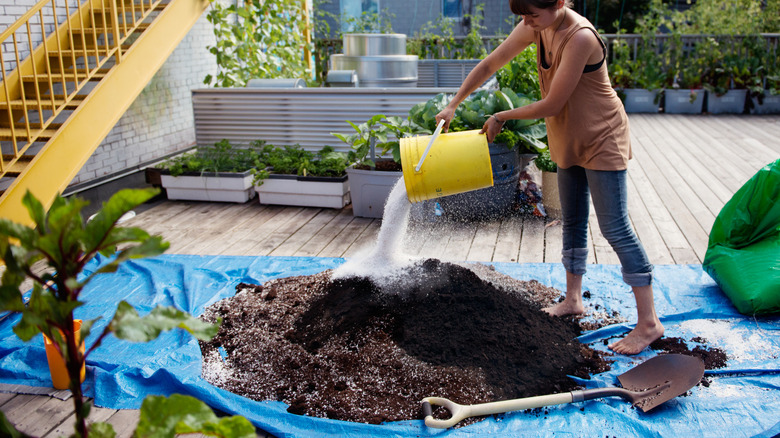 mixing a large amount of potting soil on a tarp