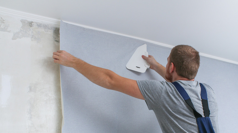 Person applying wallpaper to walls