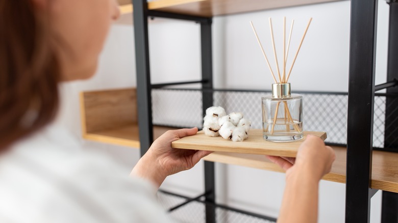 woman decorating with reed diffuser 