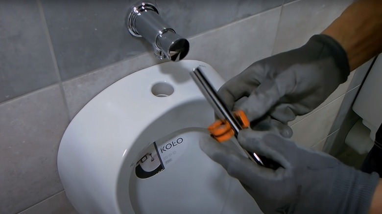 person installing residential urinal