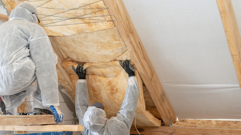 People adding insulation to attic