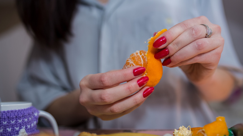 hands peeling orange