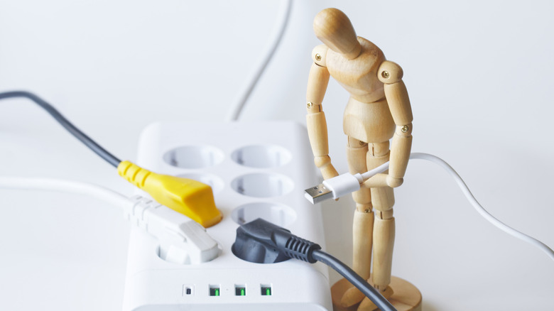An anthropomorphic figure holds a USB connector among various plugs