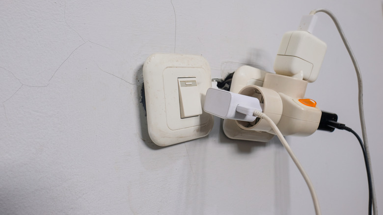 An overloaded electrical socket with multiple plugs and adapters
