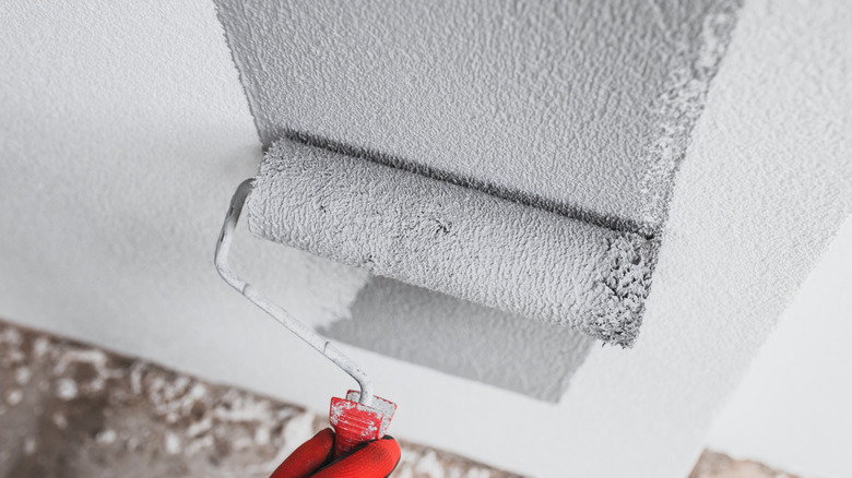 painter applying primer on wall