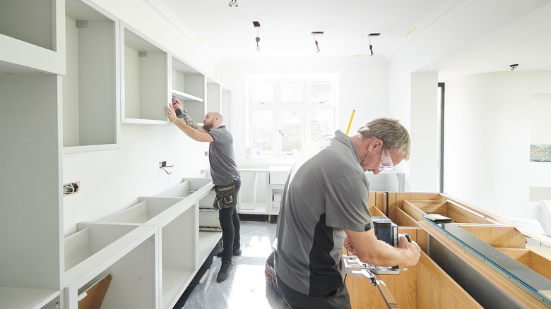 Men installing cabinets and countertops