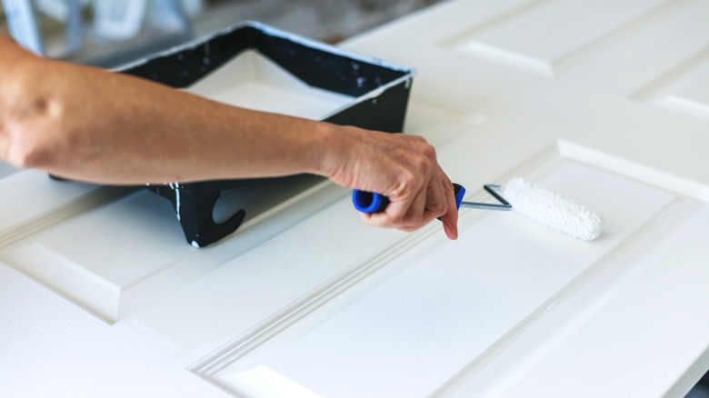 person painting a door laid flat