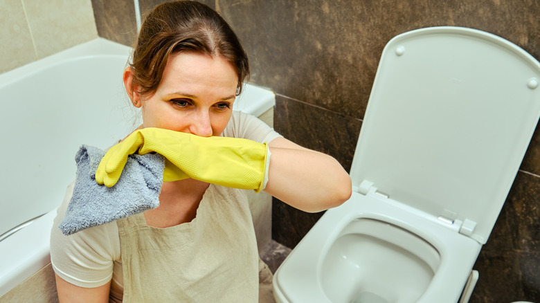 woman smells bathroom odors