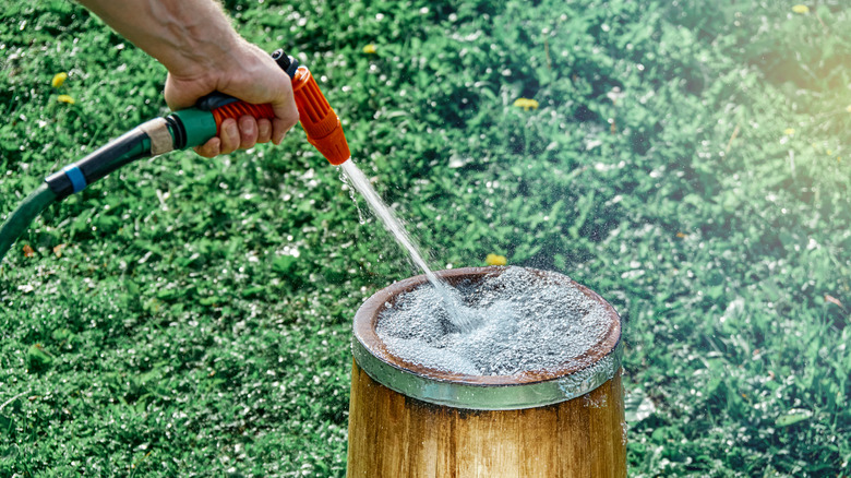 Closeup of a person filling up a bucket with water