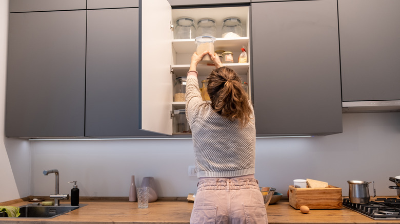 Woman cleaning a kitchen cabinet