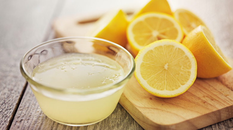 squeezing lemon juice into cup 