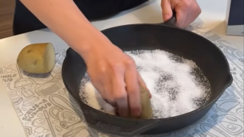 Removing rust from a pan by scrubbing with potato and baking soda