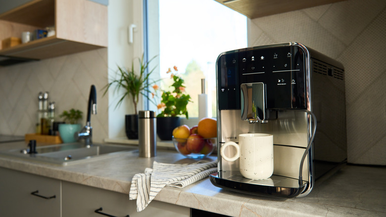 Coffee maker with a white mug in a modern kitchen