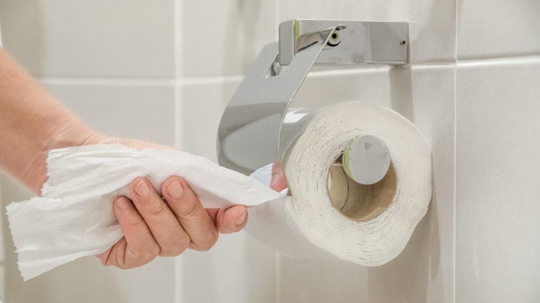 Warped toilet paper on a roll in a bathroom