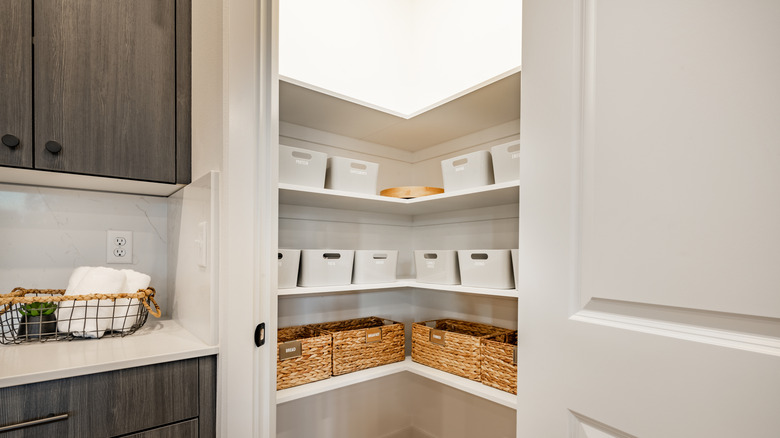 Pantry with wicker and white storage bins on shelf