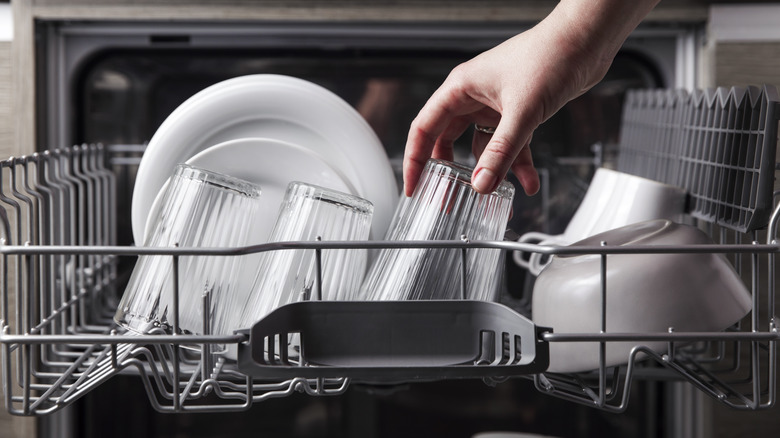 hand loading up dishwasher