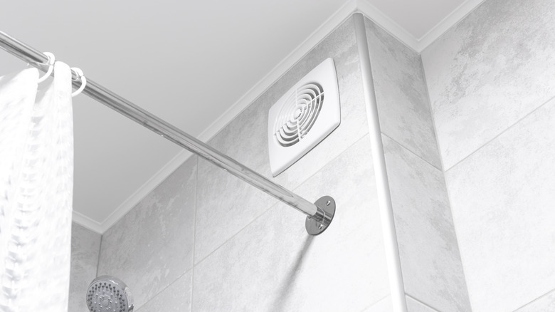 bathroom fan beside shower rod