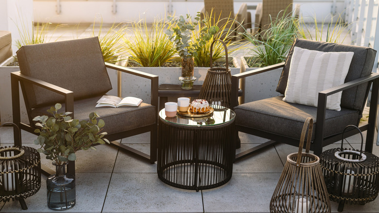 Two gray chairs and a coffee table on a balcony