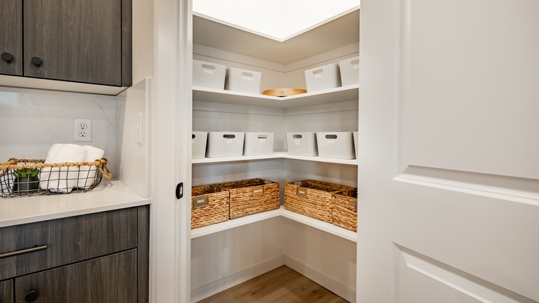 A kitchen pantry contains wicker baskets for storage.