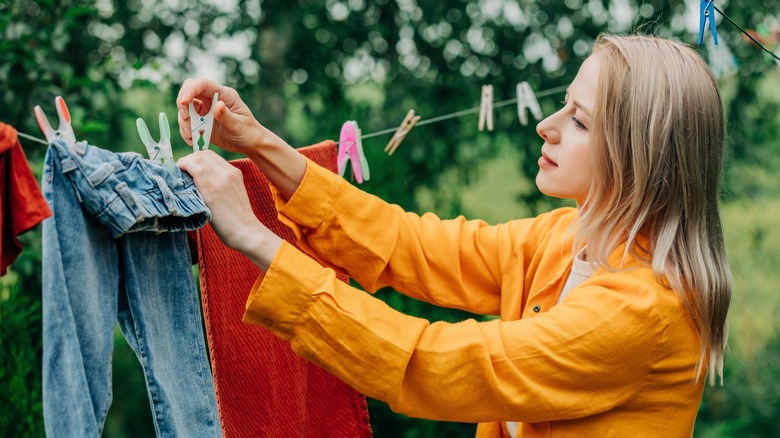 woman hanging clothes to air dry outside