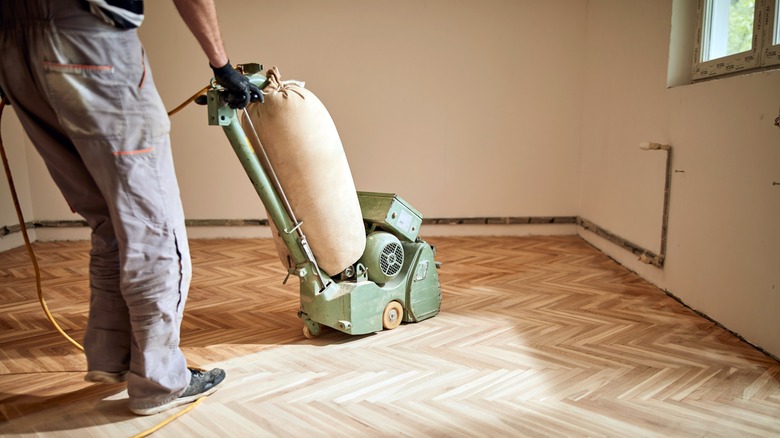 person sanding floor on diagonal